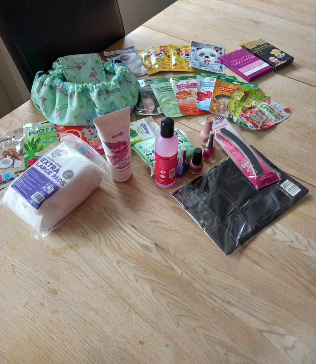 A table full of treats for a spa day, including face masks, nail files and nail varnish.